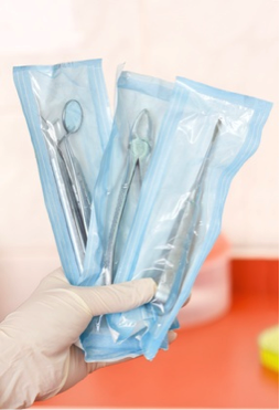 تغليف الأدواد قبل تعقيمهم في الأوتوكلاف في مركز أسنان الدولي 